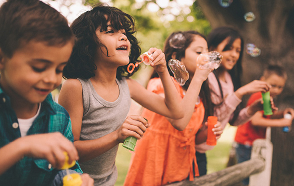 group of children blowing bubbles outside