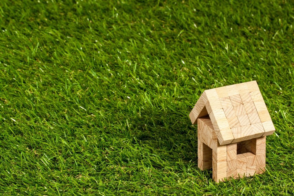 tiny wooden model house on grass