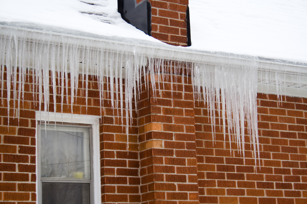 ice dams forming on the roof of house due to poorly insulated attic