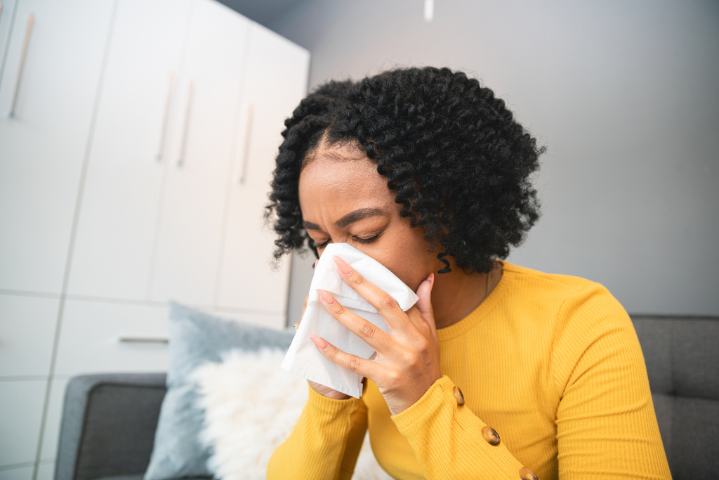 woman blowing nose due to household allergens