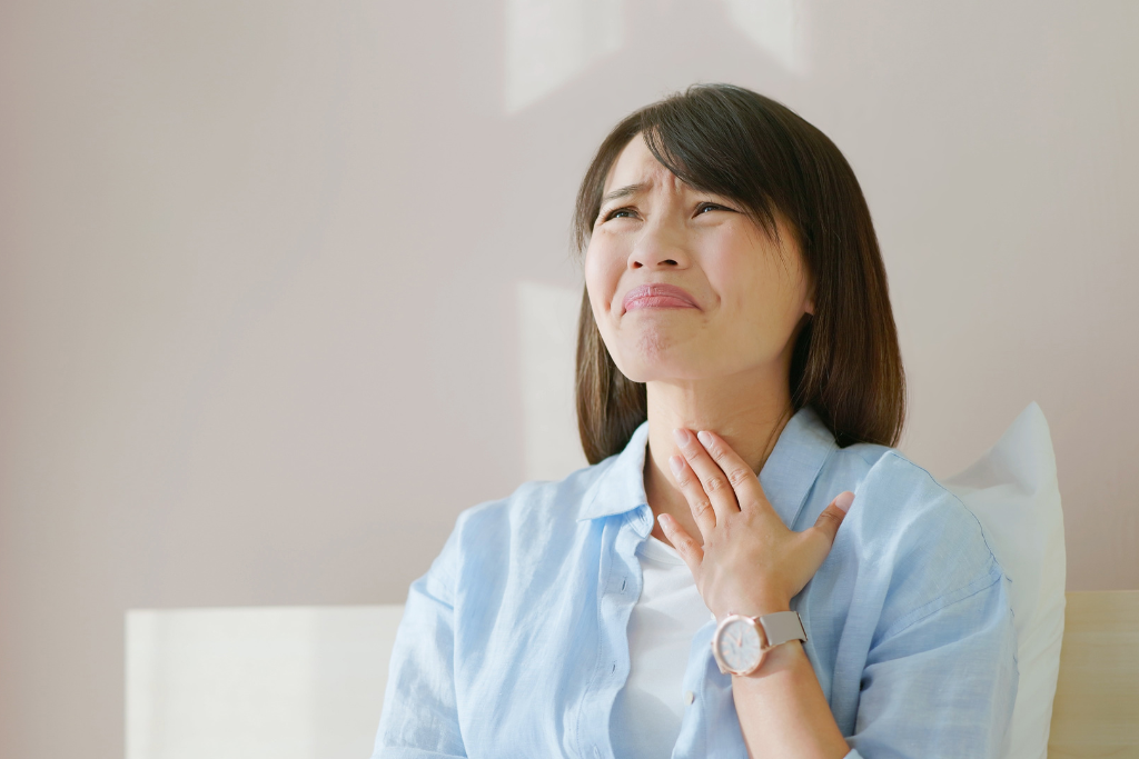 woman touching sore throat due to fall allergens and poor indoor air quality
